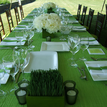 Wheat grass in green Chinese wood vessels, green glass votive holders and bunches of white peonies.  Custom green linens and chiavari chair with a custom green cushion cover complete the look.
www.lapuertaazul.com