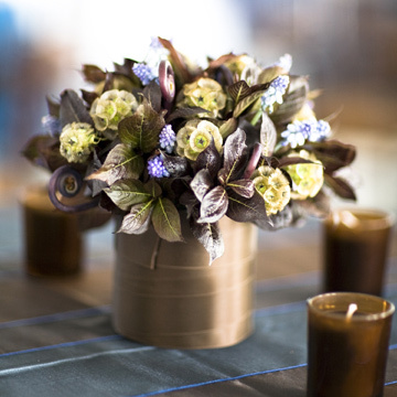 Chocolate brown leaves, fiddle head ferns and Muscari with Scabiosa pods in glass vessels wrapped in ribbon...what a look.